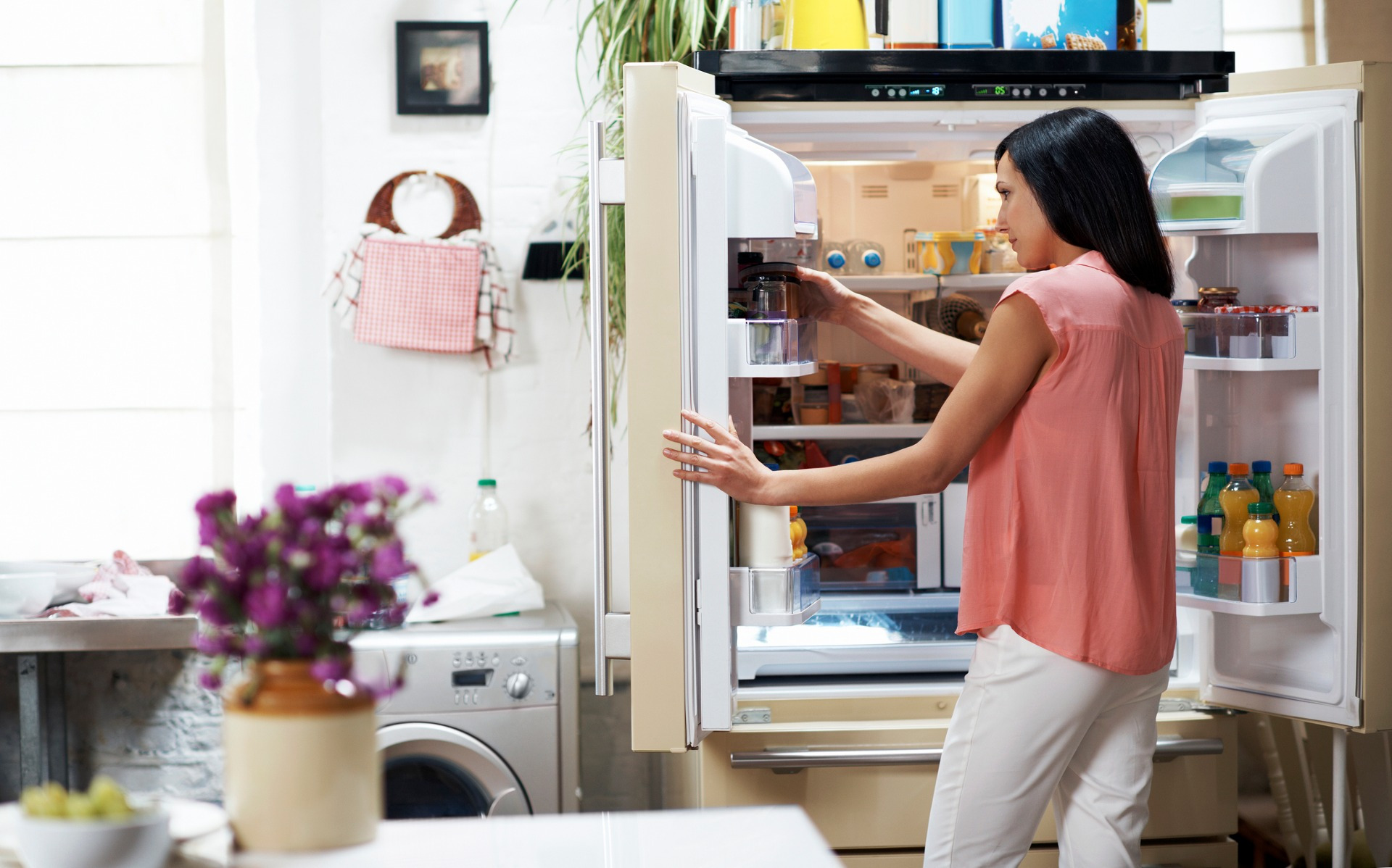 Mujer tomando un producto del refrigerador de puerta francesa