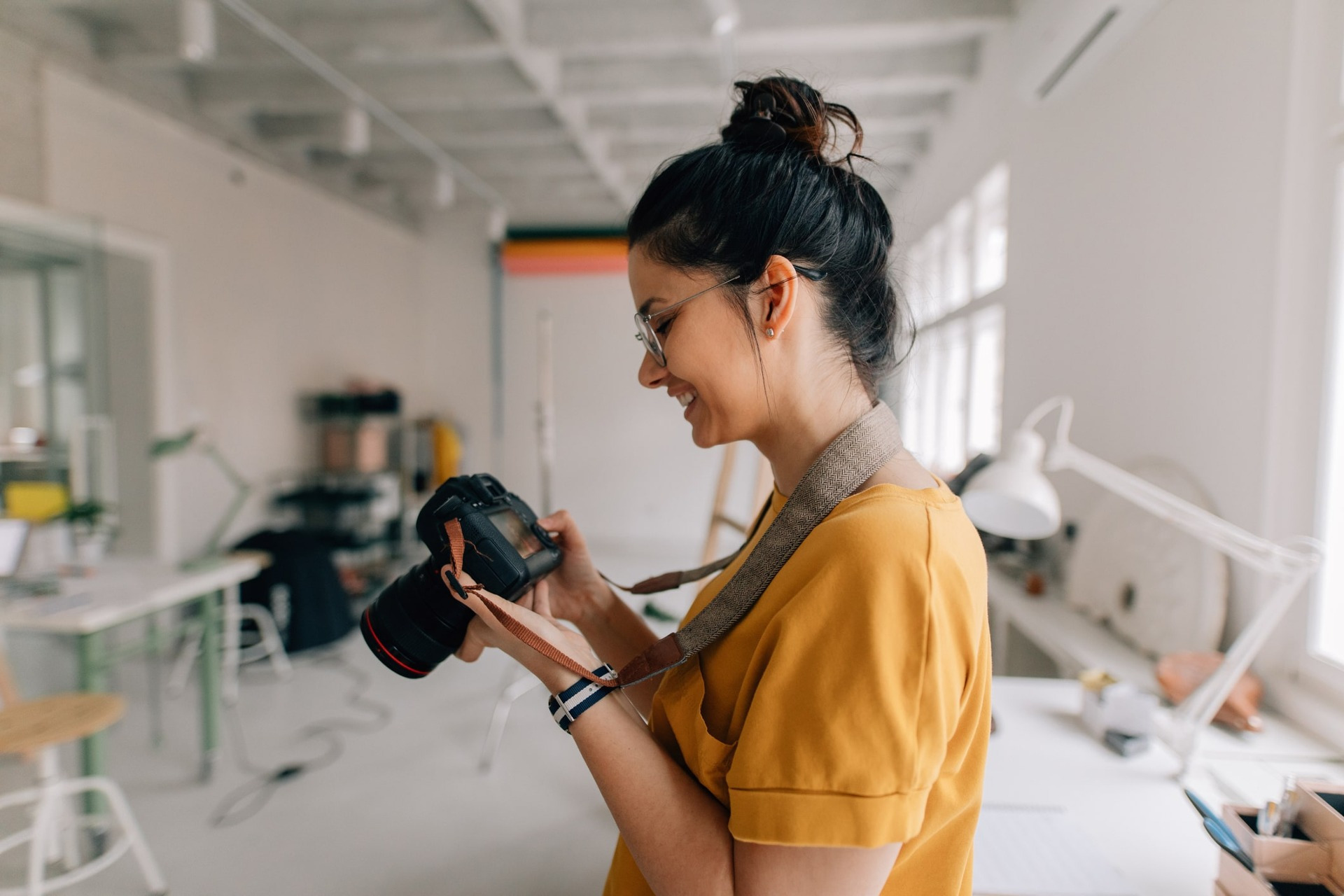 Mujer sosteniendo una cámara fotográfica en un estudio especializado.