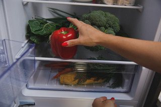 mĂŁo pegando alimento dentro da geladeira