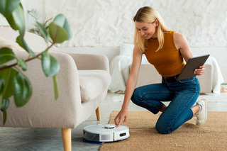 Mulher configurando robô aspirador